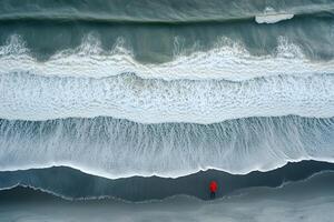 Solitude by the Sea Overhead View of Lone Figure in Red on Tranquil Beach photo