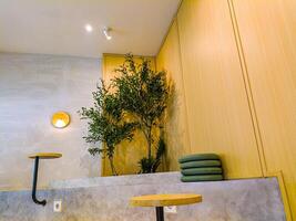 Modern cafe or workspace with minimalist design, featuring wooden walls, green plants, and simple furniture. Ideal for work or relaxation photo
