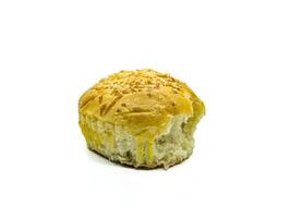 A close up image of a partially eaten bread roll with a golden-brown crust and sprinkled with shredded cheese, isolated on a white background photo