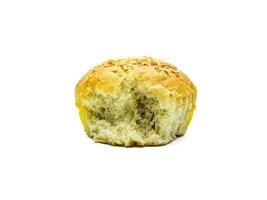 A close up image of a partially eaten sesame seed bun on a white background. The texture of the bread is soft and fluffy, with a golden brown crust sprinkled with sesame seeds photo