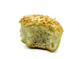 Close up of a partially eaten bread roll with a golden crust and sesame seeds on top, showcasing its soft and airy texture photo