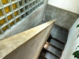 A modern staircase with a concrete wall and glass blocks, featuring a sleek design and clean lines, perfect for contemporary architecture inspiration photo