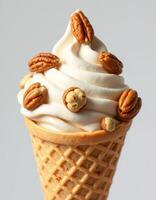 Delicious soft serve ice cream topped with pecans served in a waffle cone photo