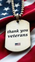 Dog tag expressing gratitude to veterans against a backdrop of an American flag photo