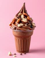 Delicious chocolate soft serve topped with nuts and chocolate chips against a pink background photo