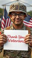 Soldier expresses gratitude with a sign thanking veterans at a military event surrounded by flags photo
