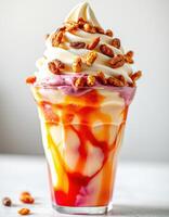 Colorful swirled soft serve topped with crunchy nuts in a clear cup on a light background photo