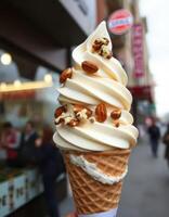 Delicious soft serve ice cream topped with nuts enjoyed on a bustling city street in cool weather photo