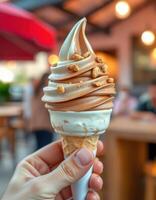 Delicious soft serve ice cream cone with chocolate and vanilla swirls topped with nuts at outdoor eatery photo