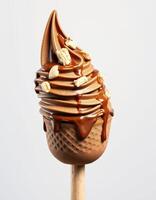 Delicious chocolate soft serve topped with caramel sauce and crunchy pieces on a cone stick photo