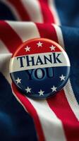 Thank you button placed on patriotic fabric featuring red, white, and blue stripes and stars photo