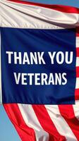 Flag displaying heartfelt message honoring veterans at a patriotic celebration in a public space photo