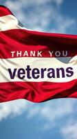 Message of gratitude towards veterans displayed on a flag against a blue sky during the day photo