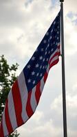 American flag waving proudly against a backdrop of cloudy skies during the afternoon photo