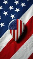 Red, white, and blue guitar pick displays patriotic theme on flag background during summer celebration photo