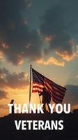 Tribute to veterans at sunset with American flag waving in the wind while two figures stand in silhouette photo