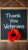 Thanking veterans with a poppy flower displayed on a chalkboard background during a remembrance celebration photo