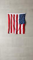Waving American flag displayed indoors against a neutral background highlighting patriotism and national pride photo