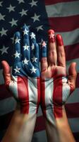 Hands painted with the American flag reflect patriotism against a backdrop of the national colors photo
