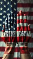 Hands painted in American flag colors expressing gratitude against a flag backdrop photo
