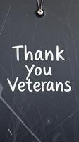 Sign expressing gratitude to veterans on a chalkboard background during a commemorative event photo