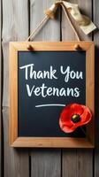 Chalkboard sign expressing gratitude to veterans with a poppy flower accent photo