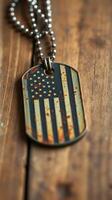Vintage dog tag with weathered American flag design resting on rustic wooden surface photo