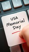Memorial Day reminder written on sticky note placed on computer keyboard for USA observance photo