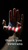 Hand with American flag design expressing gratitude to veterans portrayed in a dark background photo