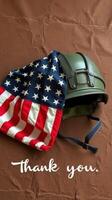 Military helmet draped with American flag expresses gratitude and respect for service members and veterans photo