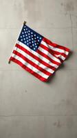 American flag draped against a textured concrete wall in a simplistic and modern setting photo