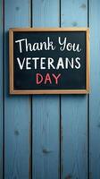 Thank you message for Veterans Day displayed on a chalkboard against a wooden backdrop photo