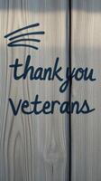 Sign expressing gratitude to veterans displayed on weathered wooden surface to honor their service during a meaningful occasion photo