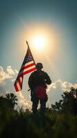 Soldier stands proudly with American flag under bright sun in open field during evening hours photo