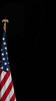 American flag displayed on a flagpole against a black background, symbolizing patriotism and national pride during a solemn occasion photo