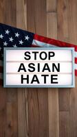 Sign displaying Stop Asian Hate with an American flag backdrop promoting awareness and solidarity against discrimination photo