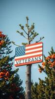 Veterans sign displayed against a backdrop of trees and vibrant orange foliage during a clear day photo