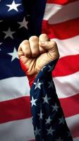 Fist raised in solidarity against the backdrop of the American flag during a patriotic celebration photo
