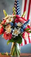 Beautiful floral arrangement with red white blue colors celebrating patriotism in front of an American flag photo