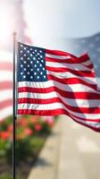 Vibrant American flag waving in the breeze surrounded by blooming flowers on a sunny day photo