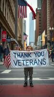 Young child holds sign to express gratitude for veterans in busy city street during daytime photo