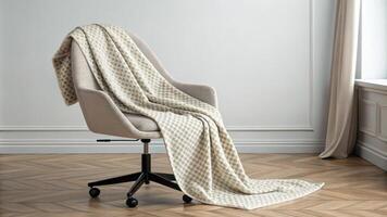 A cozy throw blanket lies draped on the office chair adding warmth while maintaining the understated minimalist theme. The subtle interplay of patterns brings visual interest. photo