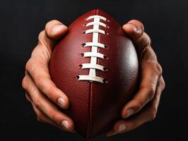 Hands gripping a football tightly in preparation for a game or practice at a sports facility during the evening photo
