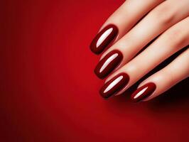 Deep red manicure showcasing shiny nails against a vibrant red background for a bold beauty statement photo