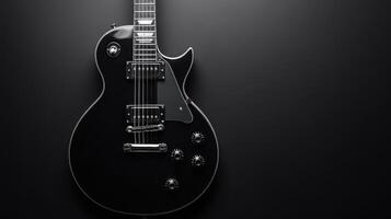 Black electric guitar with chrome hardware against a dark background highlighting its sleek design and details photo