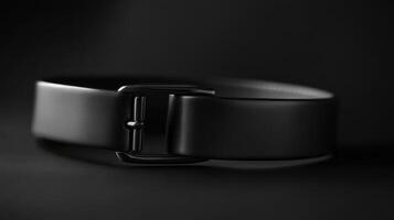 Elegant black belt displayed in a minimalist style with a focus on its smooth design and metallic buckle photo