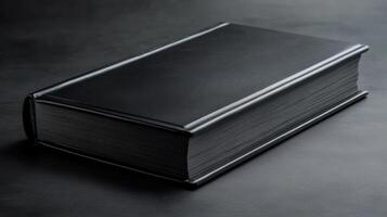 Black leather-bound book resting on a dark surface, highlighting its elegant design and craftsmanship in a minimalist setting photo