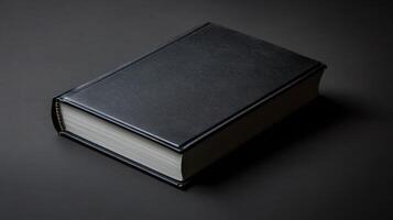 Dark leather-bound book resting on a simple dark surface lit with soft light photo