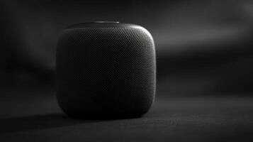 Compact black speaker on a dark surface with a soft shadow creating a sleek and modern aesthetic photo