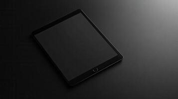 Elegant black tablet resting on a dark surface, showcasing modern technology in a minimalist setting photo